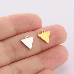 Polished stainless steel solid triangle pendants in gold and silver held on fingertips