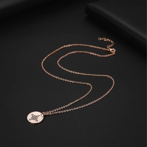 Macro shot of rose gold stainless steel necklace with a laser-engraved circular pendant
