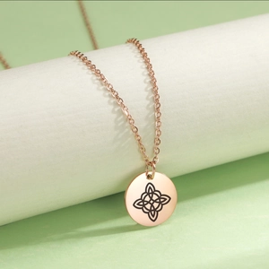Detail of rose gold stainless steel necklace featuring a laser engraved Celtic knot pendant