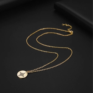 Detailed macro shot of a golden stainless steel pendant with engraved Celtic knot symbols