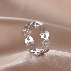 Gothic hollow skull pattern stainless steel ring on elegant beige satin background