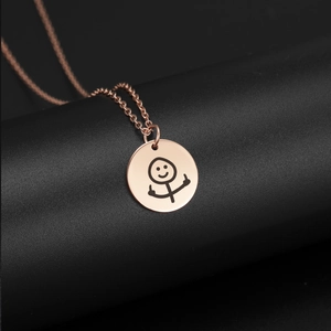 Dettaglio della collana con ciondolo oro rosa con incisione doodle e dito medio