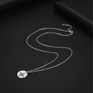 Detail of silver stainless steel necklace with S-curve chain and engraved circular charm