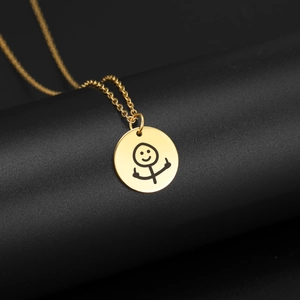 Macro della collana con ciondolo a scarabocchio dorato con faccina buffa che fa il dito