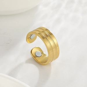 Detail of 18K gold plated stainless steel magnetic ring with brushed metal texture