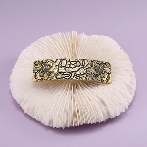 Detailed relief of peony flowers on vintage golden metal hair clip with scrolls