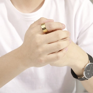 Close-up of a wide triple-spiral 18K gold-plated stainless steel ring worn on index finger