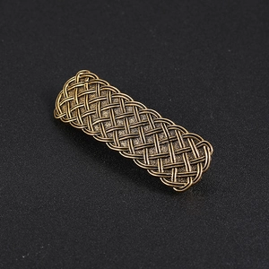 Detailed macro view of vintage bronze alloy spring hair clip with Celtic knot texture