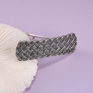 Close-up of vintage silver alloy hair clip featuring intricate Celtic knot texture