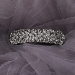 Detailed close-up of a vintage silver Celtic knot alloy hair clip on purple gauze fabric