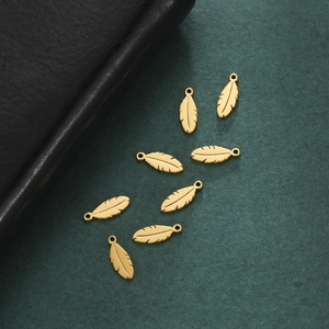 Eight gold stainless steel feather charms with textured details for jewelry DIY projects