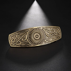 Detailed macro view of vintage bronze hair clip with celtic knots and sun embossment