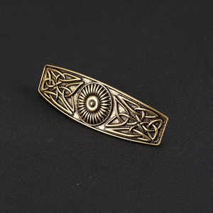Detailed close-up of retro bronze Celtic knot hair clip with sun pattern texture