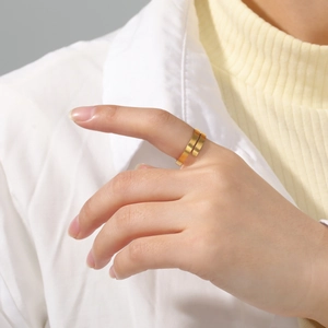 Detail eines minimalistischen, doppellagigen Goldrings aus Edelstahl am Zeigefinger getragen