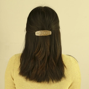 Détail d'une pince à cheveux vintage en alliage doré avec gravure de nœud celtique