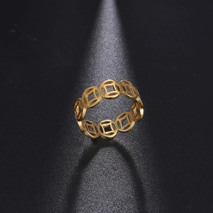 Detail of gold cutout ring featuring traditional Chinese lucky coin motifs and steel texture
