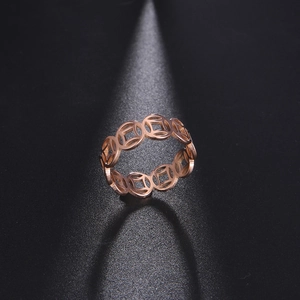 Close-up of rose gold stainless steel ring with cutout traditional coin pattern design