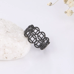Detail of vintage black stainless steel ring with traditional copper coin patterns