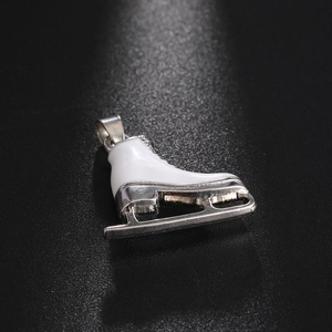 Detailed macro view of a silver roller skate pendant with white enamel and rhinestones