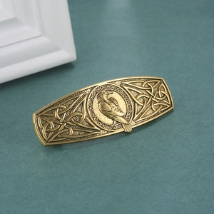 Close-up of vintage gold Viking hair clip featuring Celtic knots and eagle relief detail