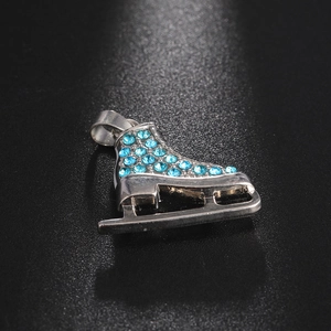 Macro shot of silver roller skate pendant with sparkling sky blue rhinestones and blade