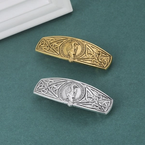 Detail of Viking hair clips featuring Celtic knots and flying eagle in gold and silver