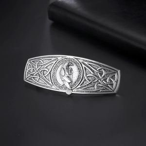 Macro shot of silver Viking raven hair clip with intricate Celtic knots on dark background