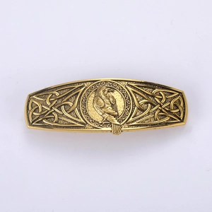 Close-up of vintage gold hair clip with eagle relief and Celtic knot patterns