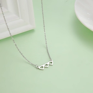 Collana minimalista d'argento con tre ciondoli a cuore traforato e catenina