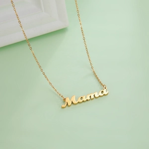Detail of gold Mama letter pendant necklace on a 18K gold plated cable chain jewelry