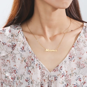 Golden Mama letter pendant necklace worn by a model on a floral chiffon shirt