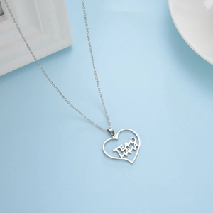 Dettaglio della collana con ciondolo a cuore e scritta TE AMO MAMA su sfondo blu