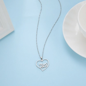 Dettaglio del ciondolo a cuore argento con incisione TE AMO MAMA su sfondo blu