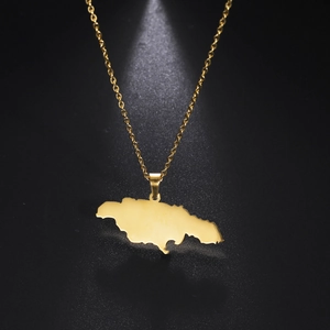 Detailopname van een gouden Jamaica kaart hanger aan een fijne ketting met schaduwen