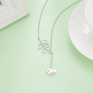 Detailed close-up of 304 stainless steel necklace with leaf and bird pendants in silver