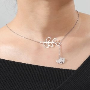 Detailed view of silver stainless steel leaf necklace with a dangling bird pendant