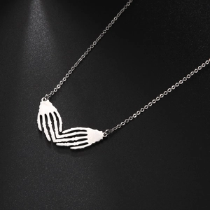Detailed view of silver skeleton hands forming a heart shape on a gothic pendant necklace