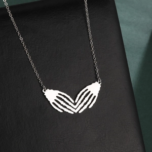 Gothic titanium steel necklace featuring hollow double skull hands forming a heart pendant