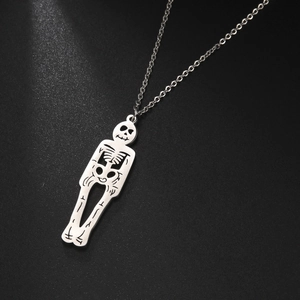 Vue détaillée d'un pendentif squelette gothique en acier argenté poli sur fond noir