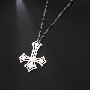 Macro shot of silver titanium steel inverted cross pendant with black edge detailing