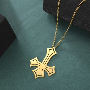 Vintage golden hollow cross pendant necklace with stainless steel chain on textured background