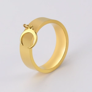 Detailed close-up of a wide gold ring featuring a delicate crescent moon pendant