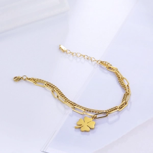 Detail of 18K gold-plated double-layer bracelet with clover pendant and paperclip chain