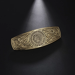 Detailed view of vintage bronze viking hair clip with Vegvisir and Celtic knot patterns