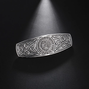 Macro detail of vintage silver hair clip with Viking Vegvisir and Celtic knot patterns