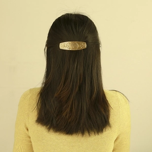 Vintage gold metal hair clip with Nordic knot hollow pattern on dark brown hair
