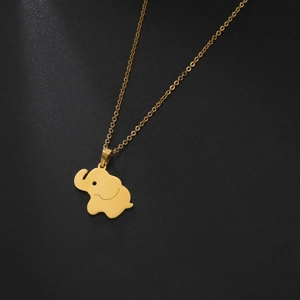 Detailopname van een gouden olifant hanger ketting op een zwarte getextureerde basis