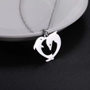 Dettaglio della collana con ciondolo a cuore doppio delfino argento su ceramica