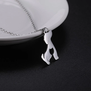 Detailed view of cutout dog and cat silhouette pendant on a delicate metal chain