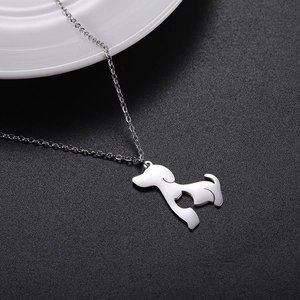 Detailed view of silver dog pendant with heart cutout on polished metal chain